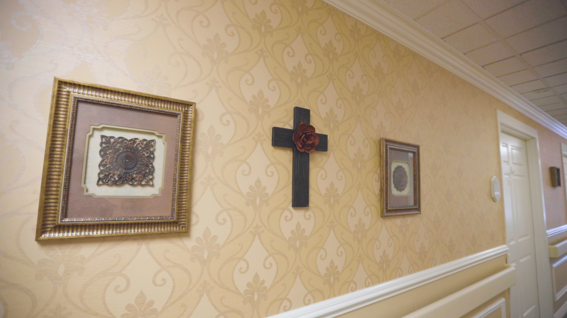 Two frames and a cross on the wall.